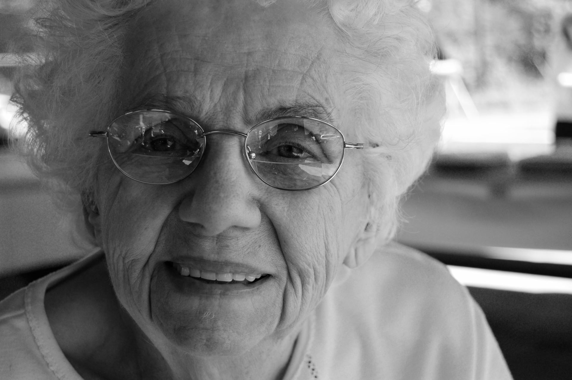 a close up of a person wearing glasses and smiling at the camera